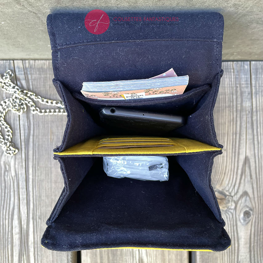 A wallet made from a gray, navy blue, and yellow babywearing scarf with bird motifs, and sun-yellow faux leather.