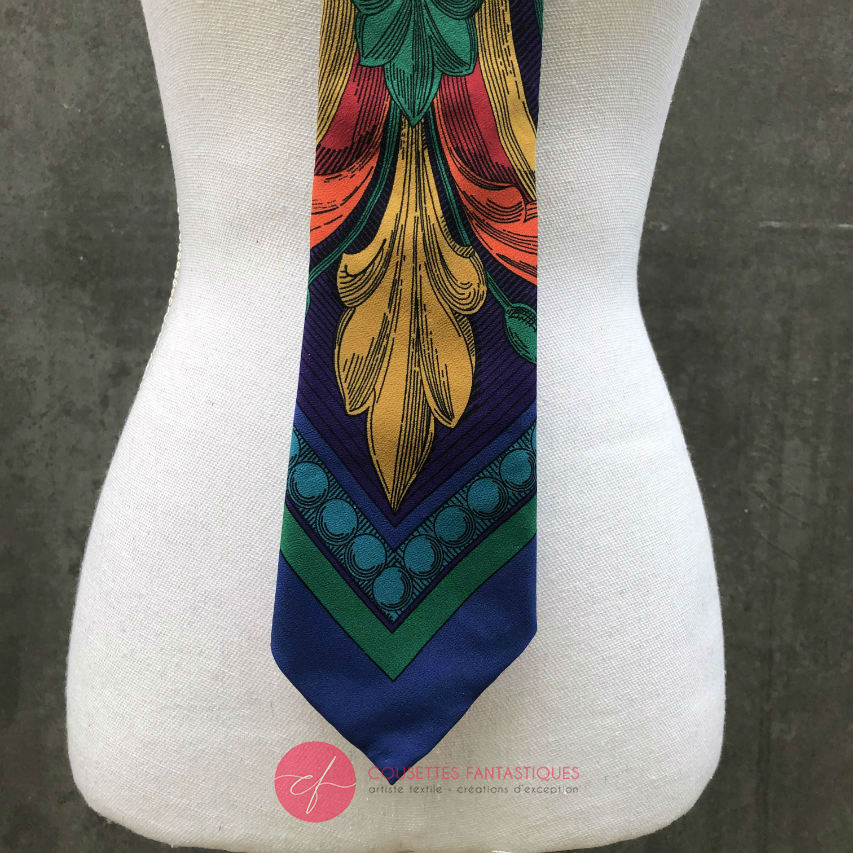 A tie made from black and gold woven wrap, marbled pattern.