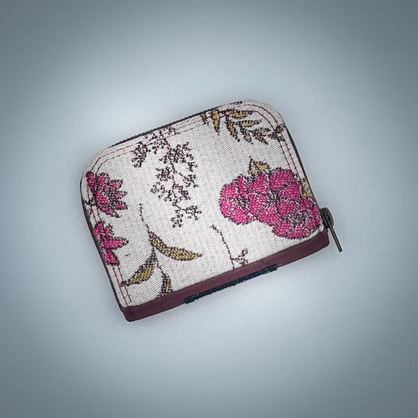 Un petit porte-cartes et monnaie zippé fait avec du tissu d'écharpe au motif floral dans les tons roses sur fond écru et du liège brique.