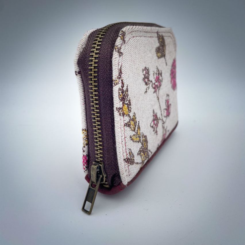 Un petit porte-cartes et monnaie zippé fait avec du tissu d'écharpe au motif floral dans les tons roses sur fond écru et du liège brique.
