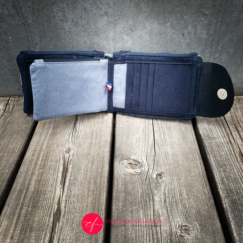 A wallet made from a midnight blue and silver geometric Art Deco patterned babywearing wrap, in midnight blue leather, midnight blue gabardine, and mouse gray poplin.