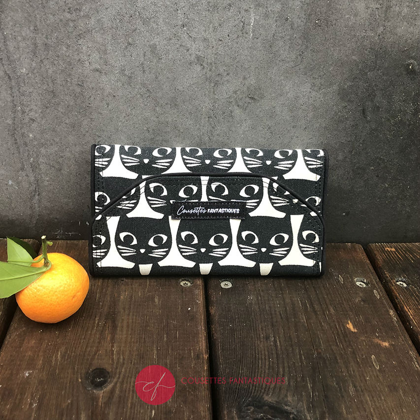 A wallet made from black and white 100% cotton canvas on the outside and pink poplin and bird-patterned cretonne on the inside.