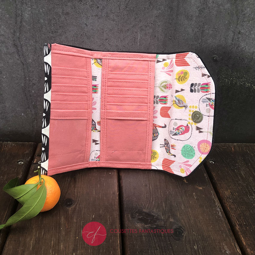 A wallet made from black and white 100% cotton canvas on the outside and pink poplin and bird-patterned cretonne on the inside.