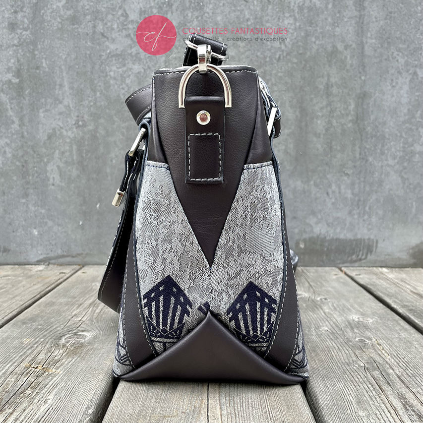 A shoulder bag made with midnight blue and silver geometric Art Deco wrap fabric, and midnight blue leather.