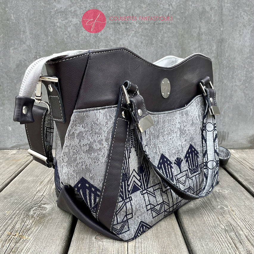 A shoulder bag made with midnight blue and silver geometric Art Deco wrap fabric, and midnight blue leather.