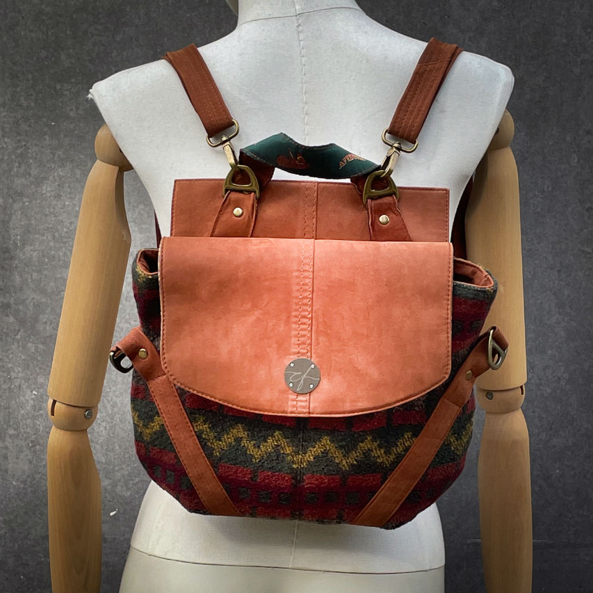 Un sac de taille moyenne, porté épaule, main, bandoulière ou dos, en suédine alezan et drap laine au motif géométrique, avec une doublure en viscose molletonée motif géométrique.