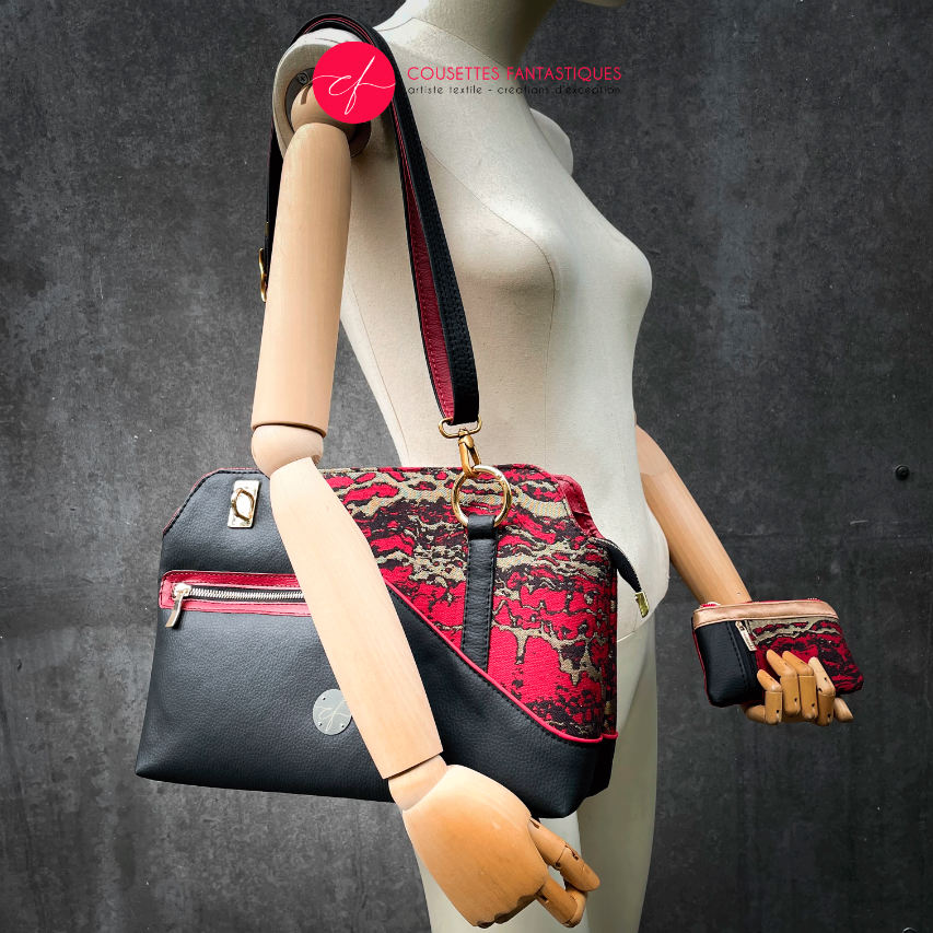 Un sac d'épaule fait en similis noir, doré et rouge, et tissu d'écharpe dans les mêmes tons, motif marbré.