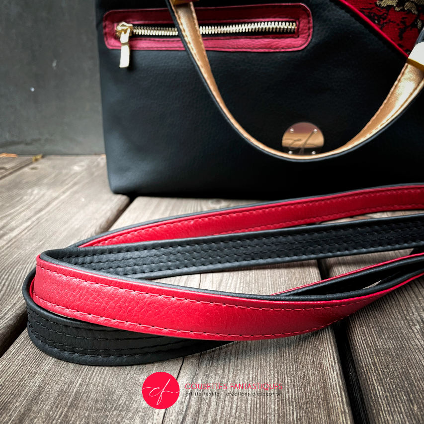 Un sac d'épaule fait en similis noir, doré et rouge, et tissu d'écharpe dans les mêmes tons, motif marbré.