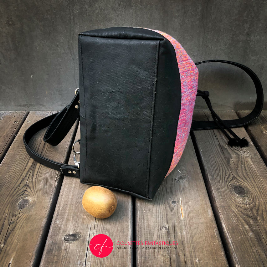 Un sac d'épaule fait en écharpe de portage dégradé miroir rose à bleu et liège noir.