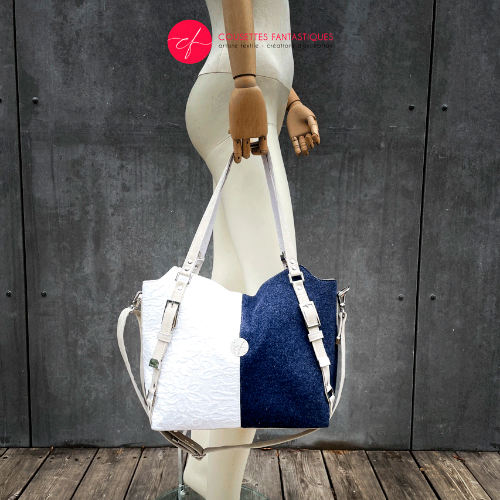 Un sac à bandoulière fabriqué en laine bleu marine et damas de coton blanc.